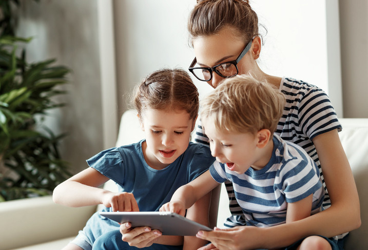 mother and children playing on tablet